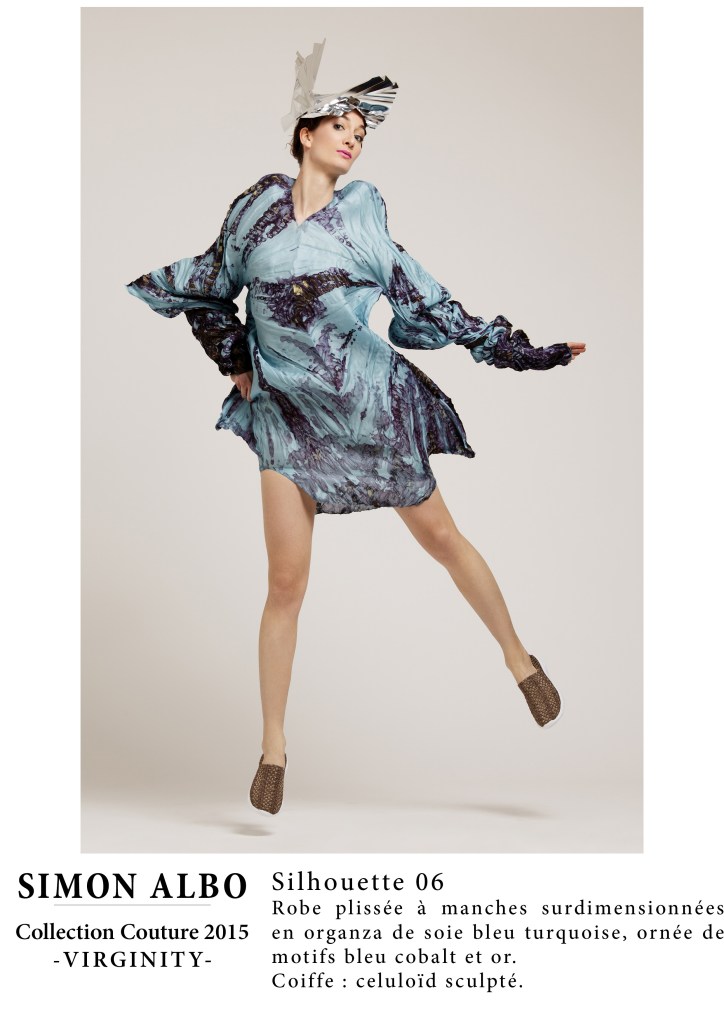 Silhouette couture Simon Albo, robe plissée à manches surdimensionnées en organza de soie bleu turquoise avec motifs bleu cobalt et or, coiffe en celluloïd sculpté. Création couture artistique.