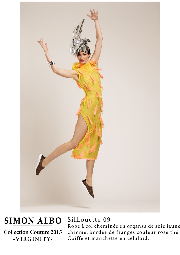 Silhouette couture Simon Albo, robe col cheminée en organza de soie jaune chrome, franges rose thé, coiffe et manchette en celluloïd sculpté, création artistique couture.